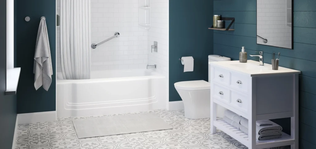 Fully remodeled bathroom featuring a Bath Fitter white acrylic bathtub with seamless wall surround, chrome grab bar, and shower curtain, alongside a white vanity with chrome fixtures against deep teal walls and patterned tile flooring