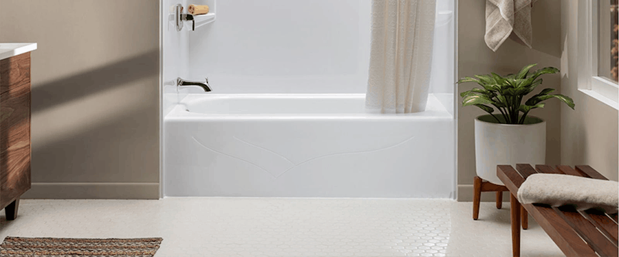 Newly installed white bathtub with modern fixtures and a clean acrylic surround